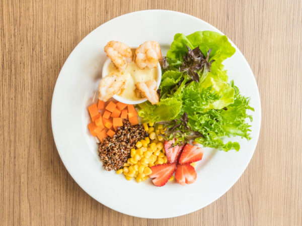 prato de refeição branco com frango grelhado, legumes e saladas